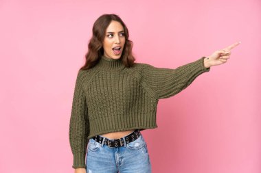 Soyutlanmış pembe arka planı olan genç bir kadın.