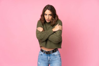 Soyutlanmış pembe arka plan donmuş genç bir kadın.