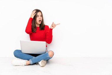 Polisle çalışan hassas kız beyaz arka planda izole edilmiş, şaşırmış ve işaret ediyor.