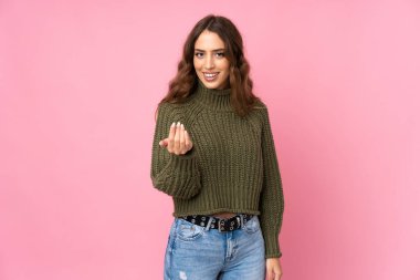 Soyutlanmış pembe arka planı olan genç bir kadın, bizimle gelmesi için davet ediyor. Gelmene sevindim.