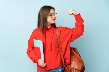 Mavi arka planda kitap tutan kız güçlü bir jest yapıyor.