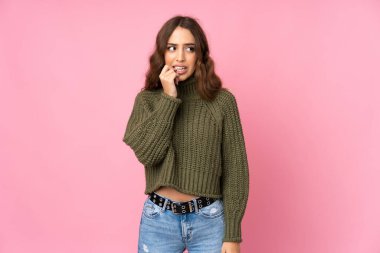 Soyutlanmış, pembe arka plan gergin ve korkmuş genç bir kadın.