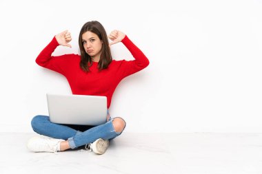 Bilgisayarla çalışan tenaager kız beyaz arka planda izole edilmiş, başparmağın aşağıda