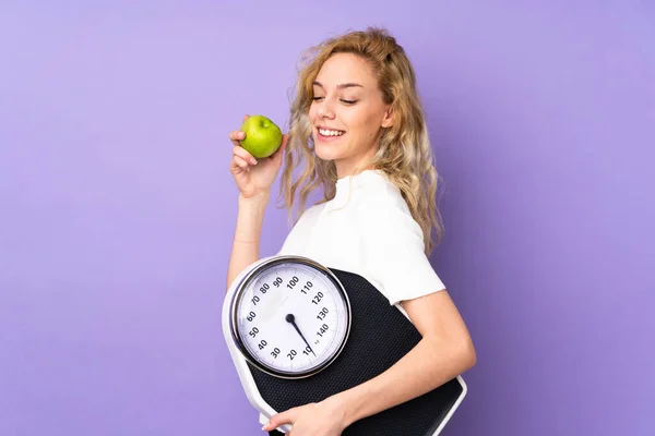 Jovem Loira Isolada Fundo Roxo Com Máquina Pesagem Com Uma — Fotografia de Stock