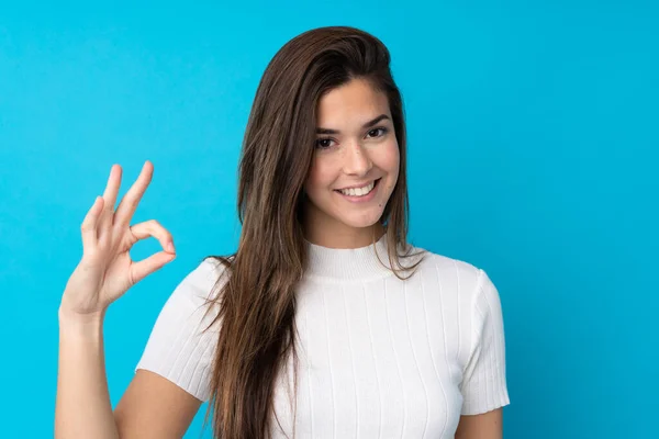 Nastolatka Dziewczyna Odizolowanym Tle Niebieski Pokazując Znak Palcami — Zdjęcie stockowe