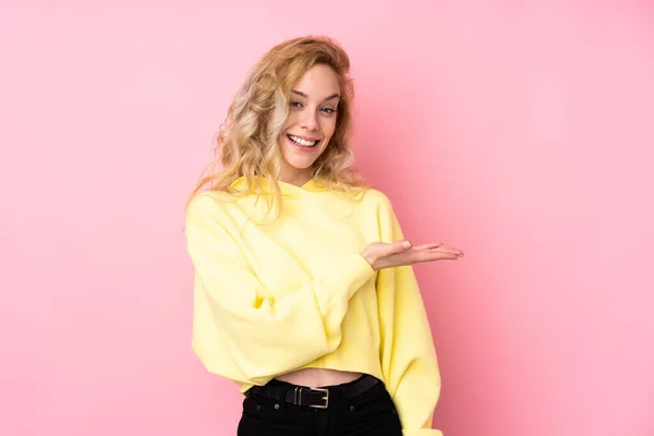 Jovem Loira Vestindo Uma Camisola Isolada Fundo Rosa Apresentando Uma — Fotografia de Stock