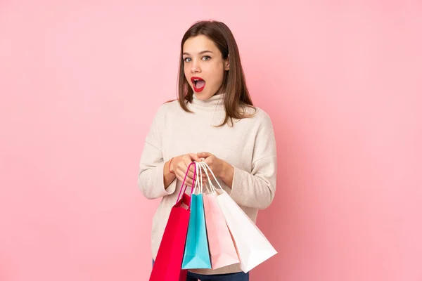 Tiener Meisje Geïsoleerd Roze Achtergrond Holding Boodschappentassen Verrast — Stockfoto