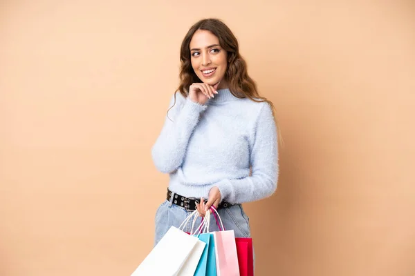 Jonge Vrouw Geïsoleerde Achtergrond Holding Boodschappentassen Denken — Stockfoto