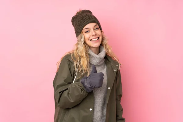 Ung Flicka Med Vinter Hatt Isolerad Rosa Bakgrund Ger Tummen — Stockfoto