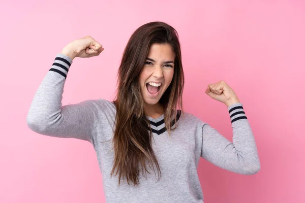 Tonårstjej Över Isolerade Rosa Bakgrund Firar Seger — Stockfoto