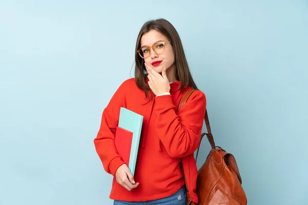 Estudiante Sosteniendo Libros Aislados Sobre Fondo Azul Pensando Una Idea — Foto de Stock