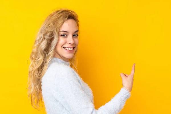 Ung Blondine Kvinde Isoleret Gul Baggrund Peger Tilbage - Stock-foto