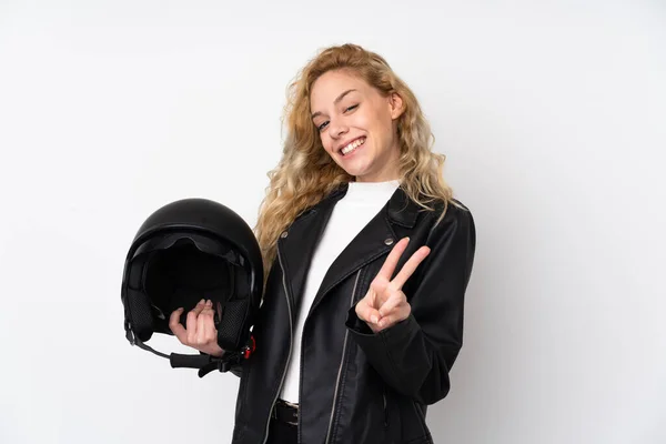 若いですブロンド女性とともにAオートバイヘルメット隔離上の白い背景笑顔とショー勝利サイン — ストック写真