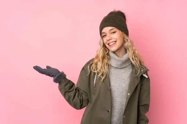 Junges Mädchen Mit Wintermütze Isoliert Auf Rosa Hintergrund Hält Kopierraum — Stockfoto