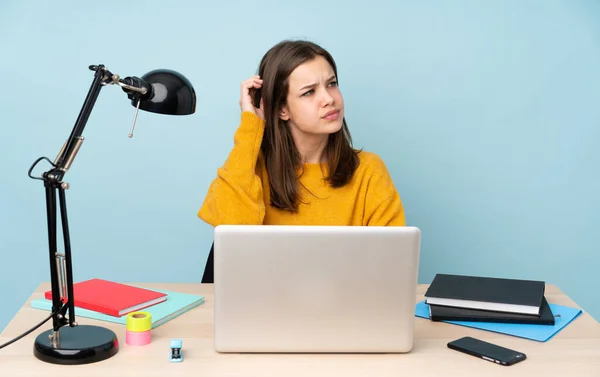 Student girl studying in her house isolated on blue background having doubts