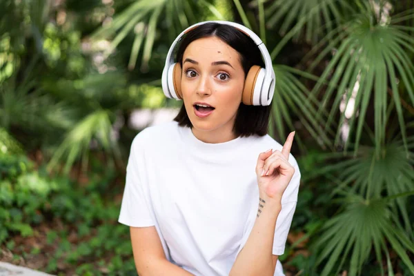 Mujer Joven Caucásica Con Auriculares Aire Libre Pensando Una Idea —  Fotos de Stock