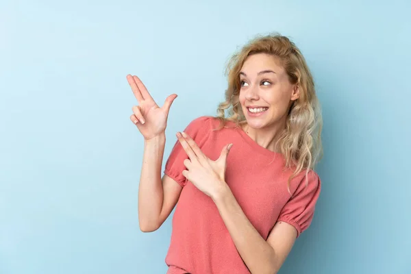 Mavi Arka Planda Izole Edilmiş Genç Sarışın Kadın Işaret Parmağıyla — Stok fotoğraf