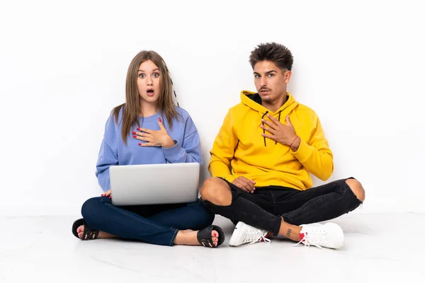 Junges Paar Mit Laptop Auf Dem Boden Sitzend Isoliert Auf — Stockfoto