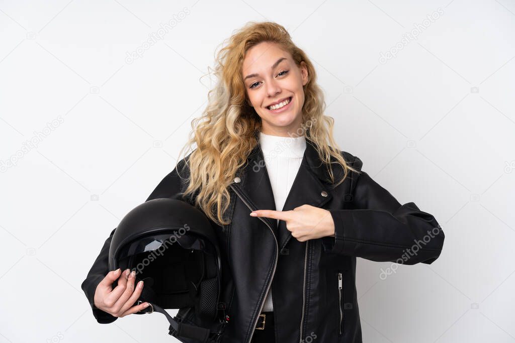 Young blonde woman with a motorcycle helmet isolated on white background and pointing it