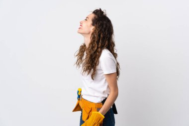 Genç elektrikçi beyaz arka planda izole edilmiş. Yan pozisyonda gülüyor.