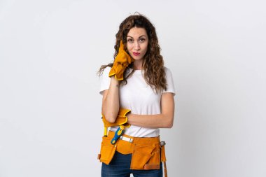 Genç elektrikçi beyaz arka planda izole edilmiş bir fikir düşünüyor.