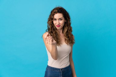 Mavi arka planda izole genç beyaz kadın para hareketi yapıyor.