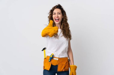 Genç elektrikçi beyaz arka planda izole edildi. Başparmakları havada çünkü iyi bir şey oldu.