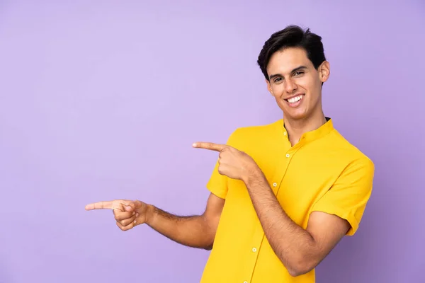 Чоловік Над Ізольованим Фіолетовим Тлом Вказуючи Пальцем Бік Представляючи Продукт — стокове фото