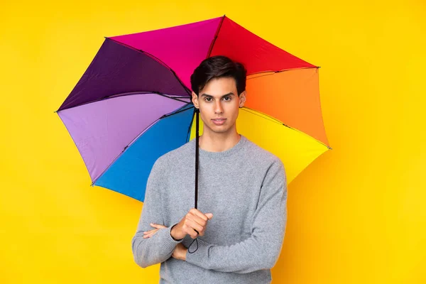 Muž Držící Deštník Nad Izolovaným Žlutým Pozadím Zkříženýma Rukama — Stock fotografie