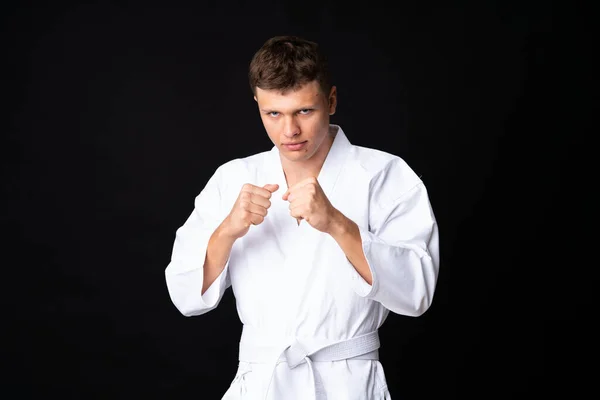 Mladý Muž Dělá Karate Přes Izolované Černé Pozadí — Stock fotografie