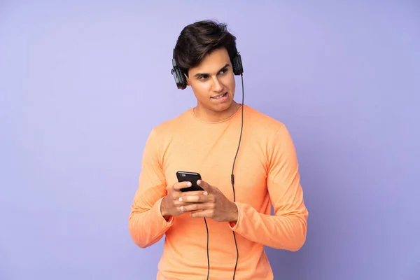 Mann Über Isolierten Lila Hintergrund Musik Hören Mit Einem Handy — Stockfoto