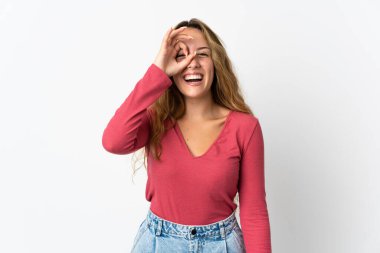 Mavi arka planda izole edilmiş genç sarışın kadın parmaklarıyla işaret veriyor.