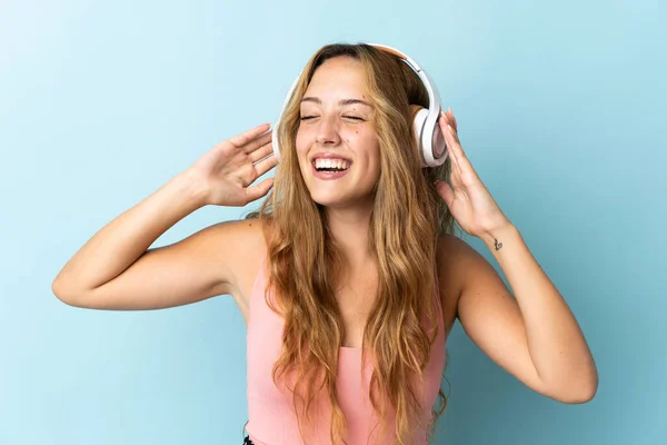 Νεαρή Ξανθιά Γυναίκα Απομονωμένη Μπλε Φόντο Ακούγοντας Μουσική Και Τραγουδώντας — Φωτογραφία Αρχείου
