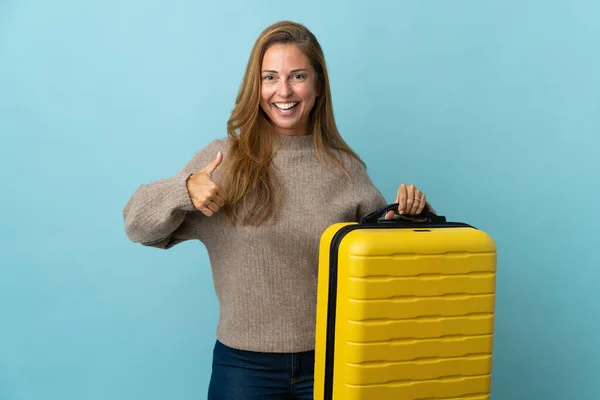 Reisenden Mittleren Alters Frau Hält Einen Koffer Isoliert Auf Blauem — Stockfoto