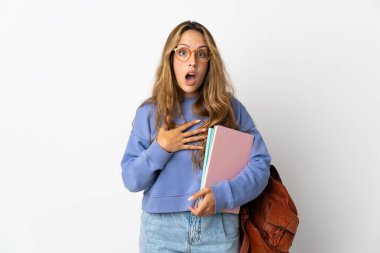 Beyaz arka planda izole edilmiş genç bayan şaşırmış ve şaşırmış görünüyor.