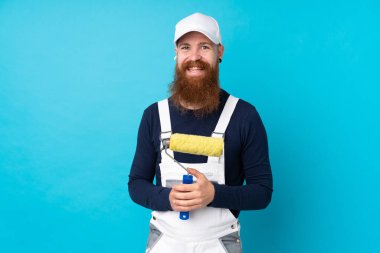 Uzun sakallı bir ressam mavi arka planda alkışlıyor.