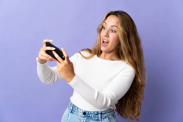 Giovane Donna Bionda Isolata Sfondo Viola Che Gioca Con Telefono — Foto Stock