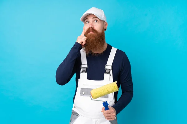 孤立した青の背景を考えながら長い髭を持つ画家 — ストック写真