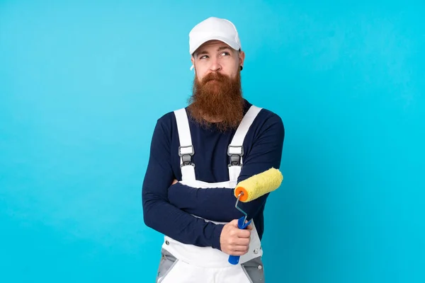 孤立した青の背景を考えながら長い髭を持つ画家 — ストック写真