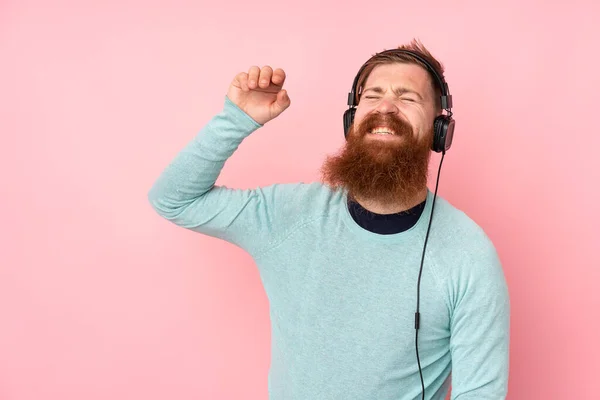 Homem Ruivo Com Longa Barba Sobre Fundo Rosa Isolado Ouvindo — Fotografia de Stock