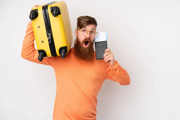 長いです髭を生やした男上の隔離された白い背景で休暇でスーツケースとパスポートと驚き — ストック写真