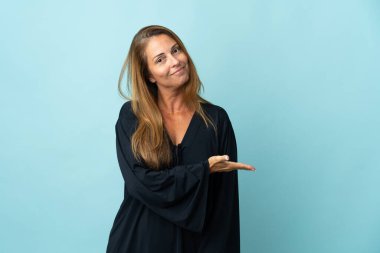 Mavi arka planda izole edilmiş orta yaşlı Brezilyalı bir kadın gülümseyerek bir fikir sunuyor.