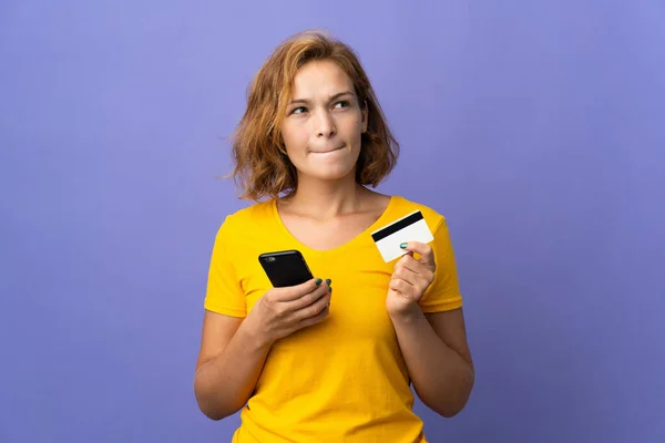 Jonge Georgische Vrouw Geïsoleerd Paarse Achtergrond Kopen Met Mobiele Telefoon — Stockfoto