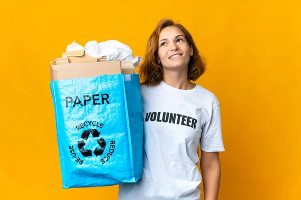 考えをリサイクルする紙の袋を持っている若いグルジアの女の子を検索しながら アイデアをリサイクルする — ストック写真