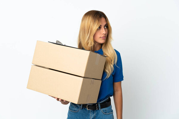 Young blonde Uruguayan delivery woman isolated on white background looking to the side