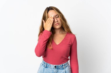 Mavi arka planda başağrısı olan genç sarışın kadın.