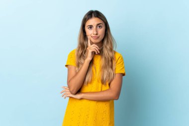 Soyutlanmış mavi arka planda genç bir İspanyol kadın.