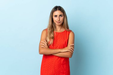 İzole edilmiş mavi arka planda genç İspanyol kadın üzgün hissediyor.
