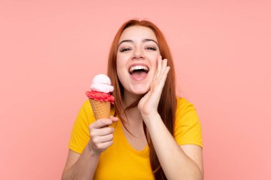 Kornet dondurması ile izole edilmiş arka planda ağzı açık bağıran genç bir kız.