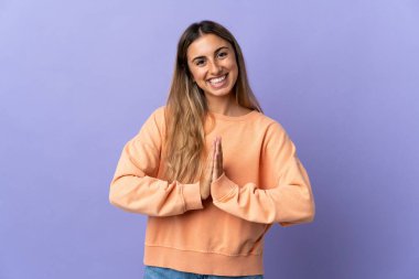 İzole edilmiş mor geçmişi olan genç İspanyol kadın avuç içlerini bir arada tutuyor. İnsan bir şey ister.